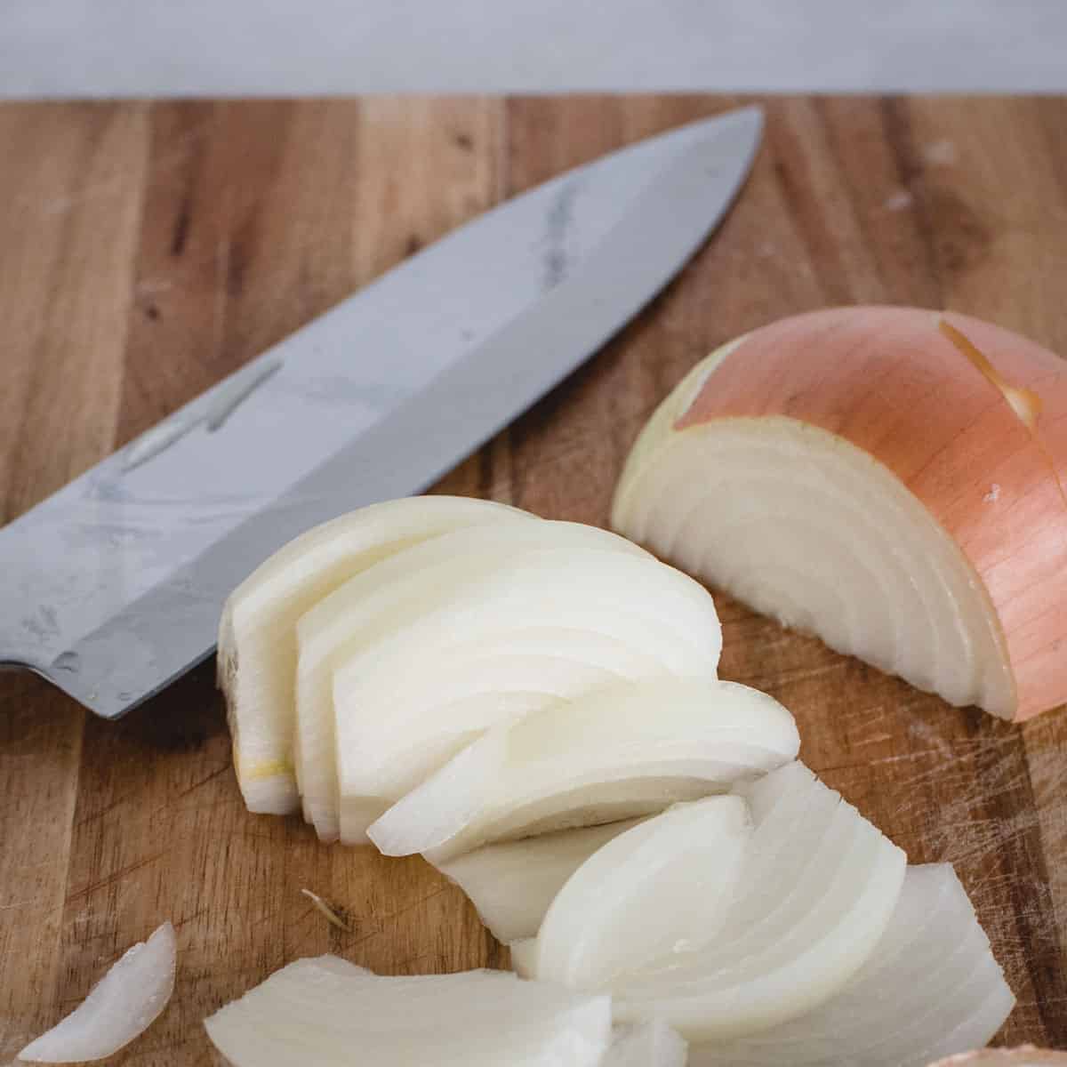 onion sliced into wedges on a cutting board