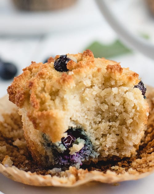 close up picture of an almond flour blueberry muffin with bite taken out