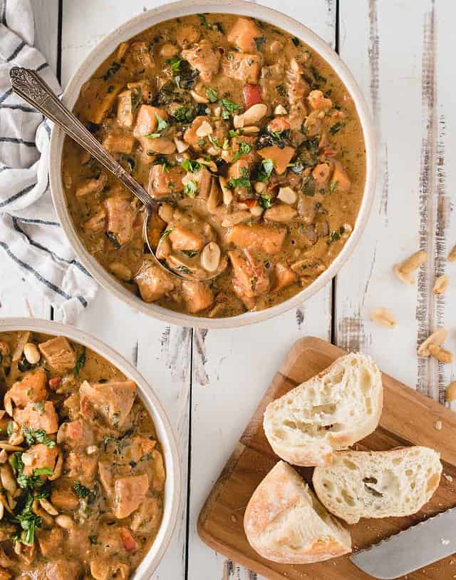 African peanut soup from overhead in bowls next to sliced bread