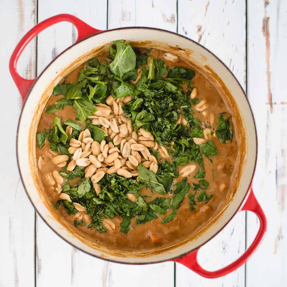 overhead of soup from overhead with spinach and peanuts on top