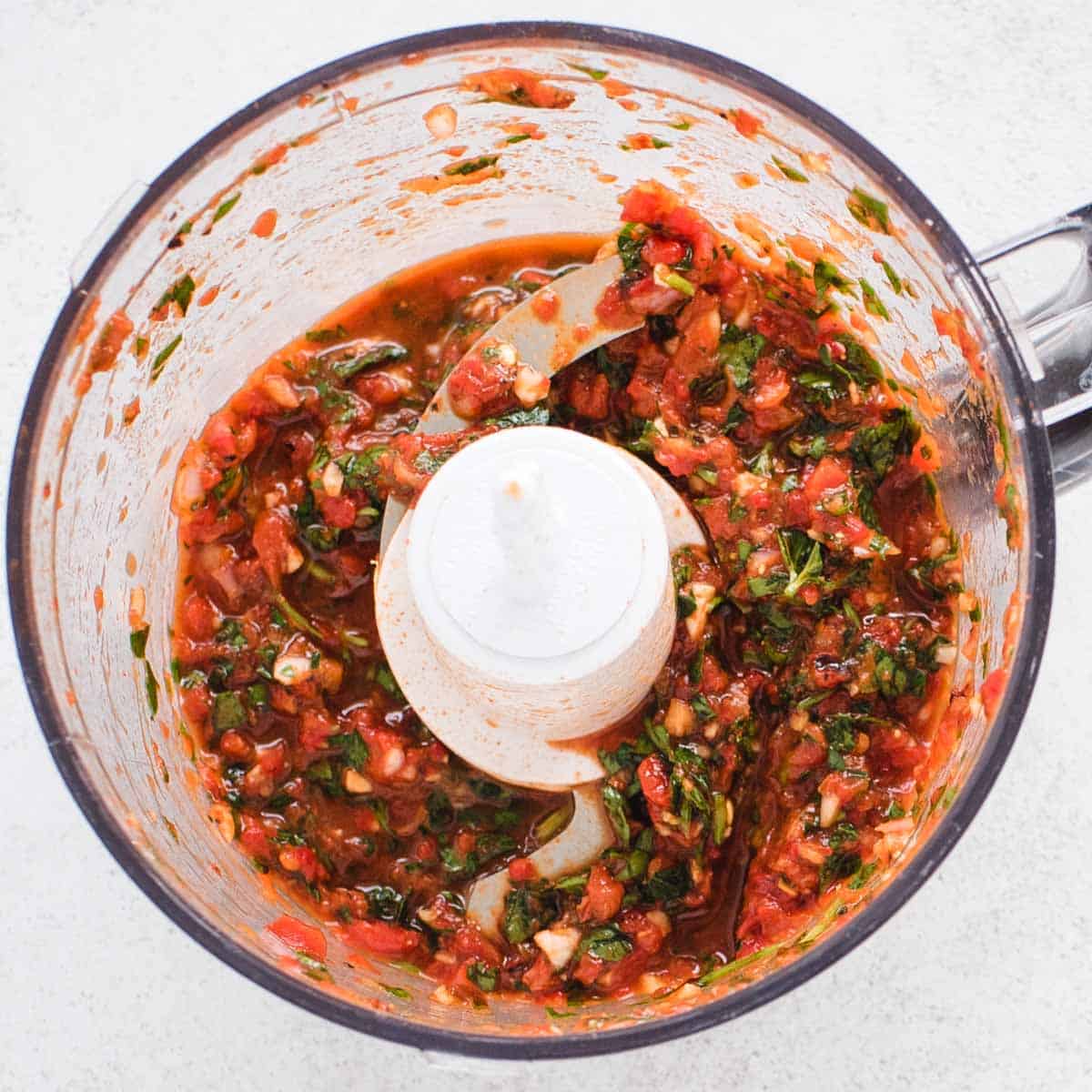 red chimichurri in a mini food processor after blending