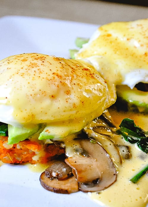 sweet potato eggs benedict with mushrooms and hollandaise sauce on a plate