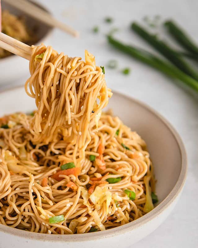 close up of teriyaki noodles being lifted up by chopsticks