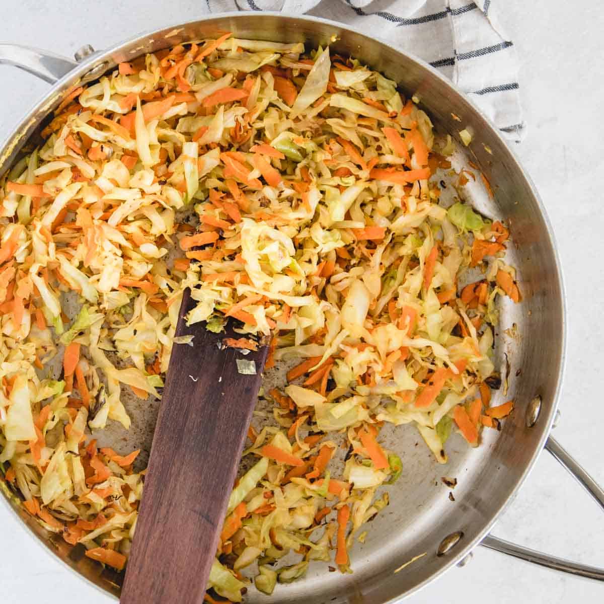 sauteed shredded cabbage and carrots in a large skillet