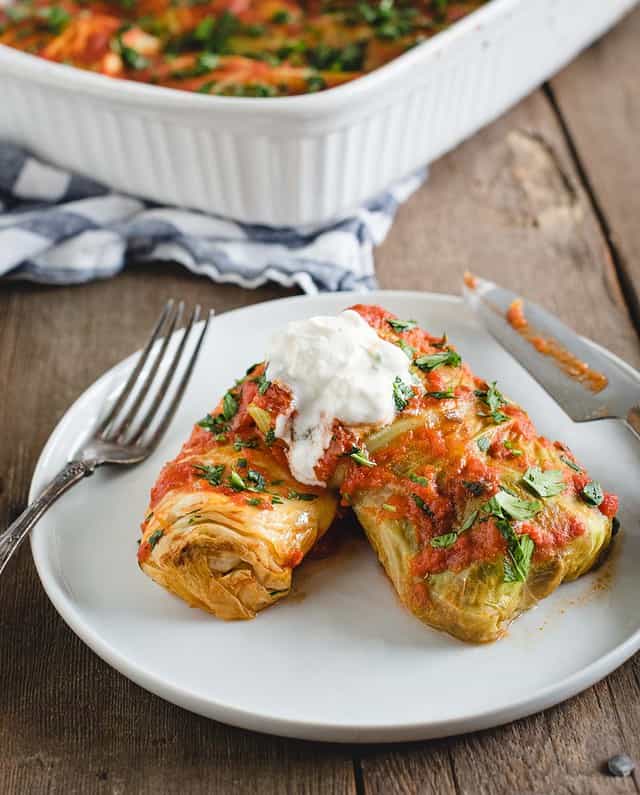 side angle cabbage rolls on a plate with sour cream on top