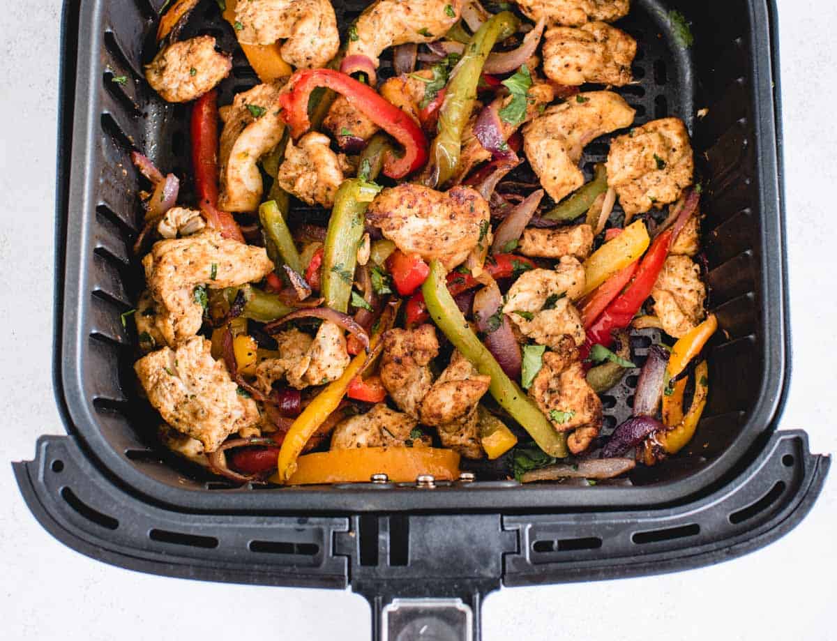 cooked fajita chicken and peppers in an air fryer basket