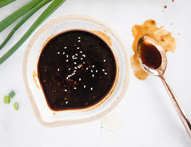 overhead of teriyaki sauce in a bowl and on a spoon next to it