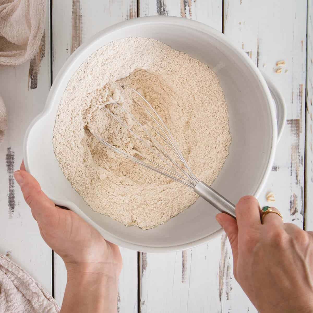 Hand whisking flour mixture in a bowl