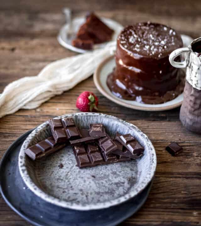 chocolate squares on a plate with cake in background