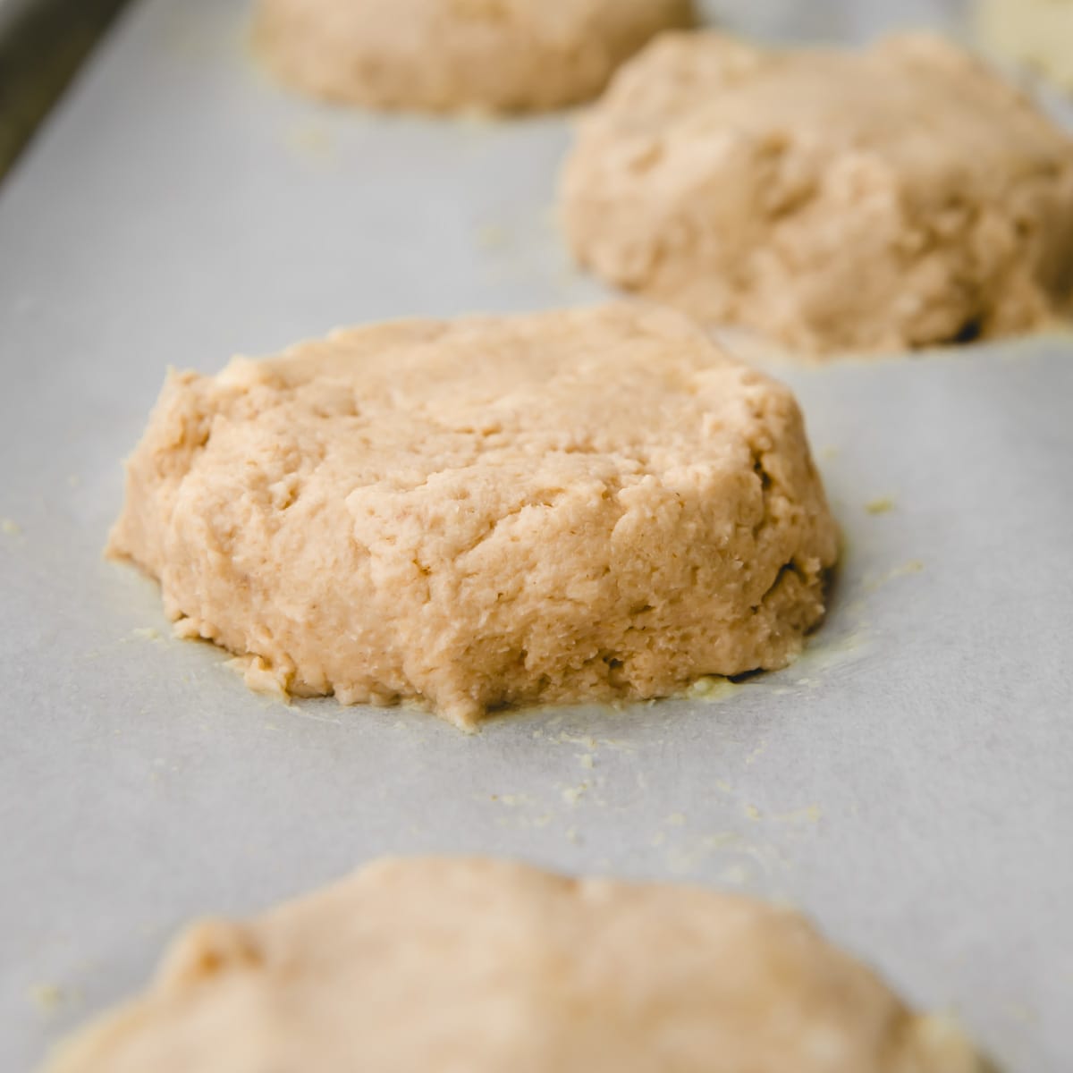 raw biscuit dough on a baking sheet before baking