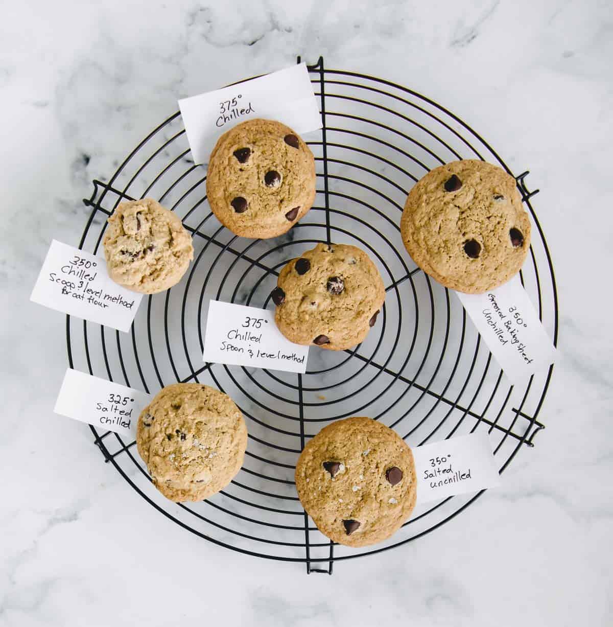 cookies on a cooling rack with paper labels next to each one with recipe testing notes