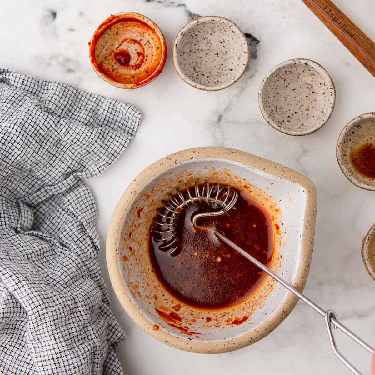 gochujang sauce in a bowl with a whisk