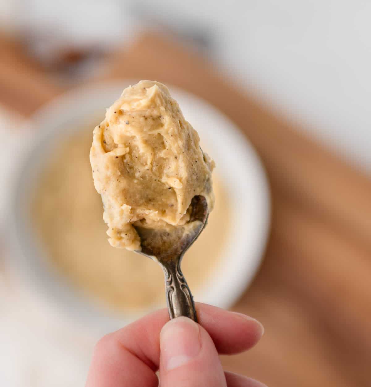 Hand holding up spoon with compound butter on it