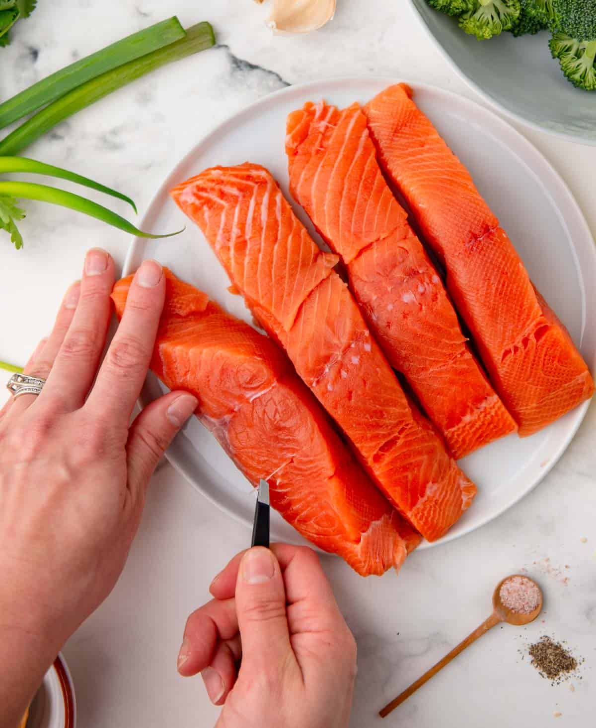 bone being removed from salmon with tweezers