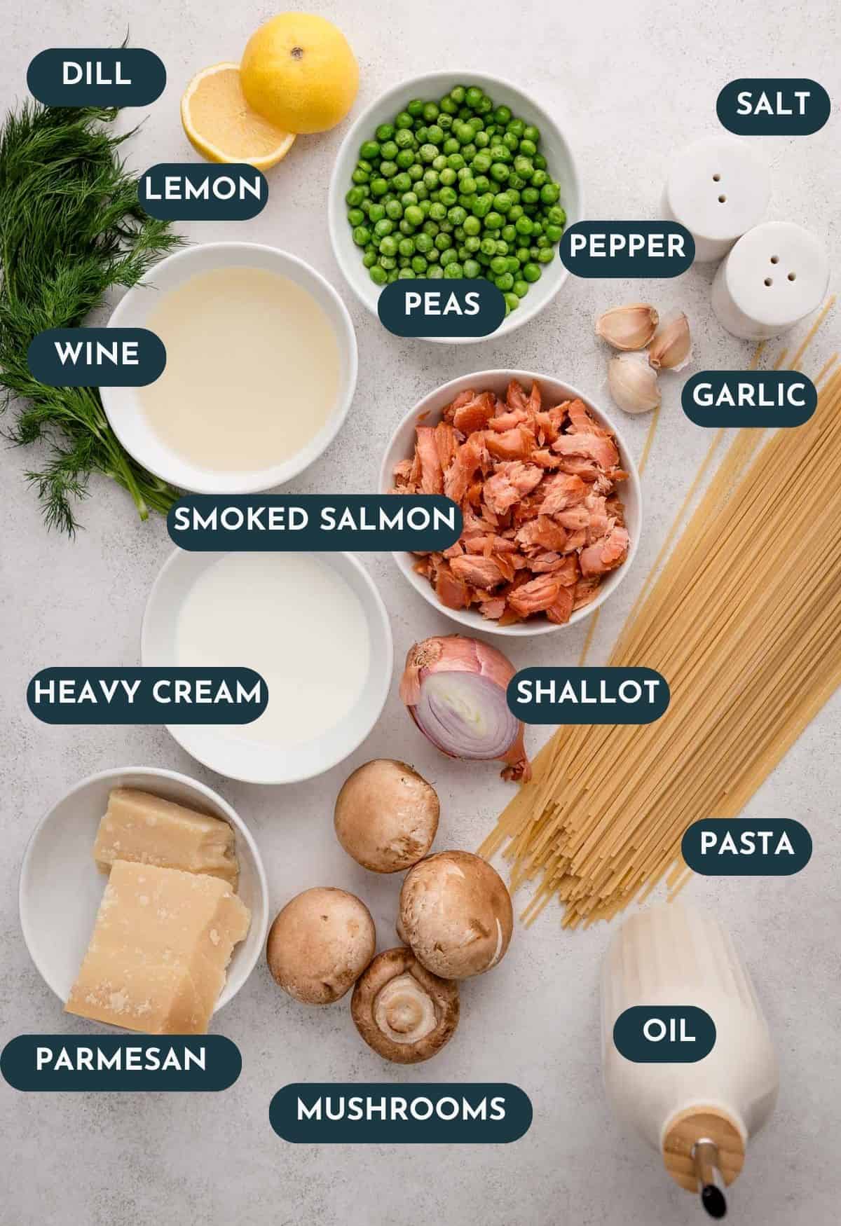 Ingredients for a pasta dish, including smoked salmon, peas, mushrooms, pasta, lemon, and seasonings on a table.