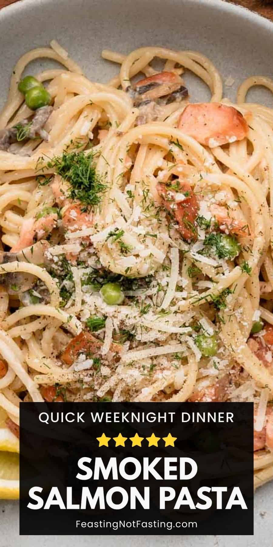 A plate of smoked salmon pasta with peas, dill, grated cheese, and a creamy sauce.